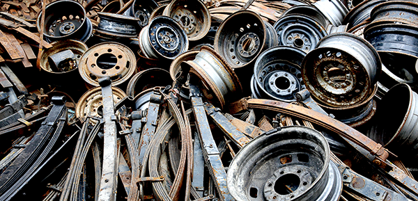Pile of scrap metal consisting of discarded wheels and car parts